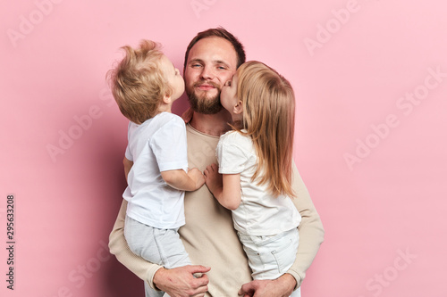little daughter and son kissing their father isolated over a pink background, close up portrait, isolated pink background, relationship, fatherhood