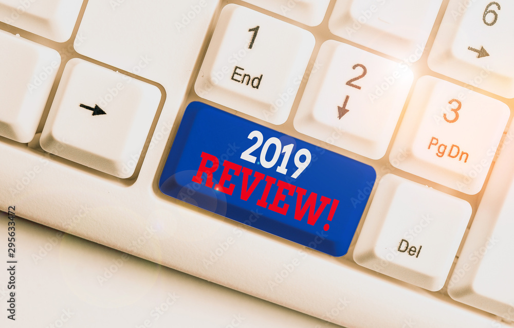 Text sign showing 2019 Review. Business photo text remembering past year events main actions or good shows White pc keyboard with empty note paper above white background key copy space Text sign showing 2019 Review. Business photo text remembering past year events main actions or good shows White pc keyboard with empty note paper above white background key copy space