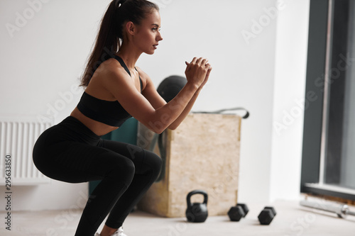Fototapeta Naklejka Na Ścianę i Meble -  Photo of slim fitness model in black sportswear isolated on white background
