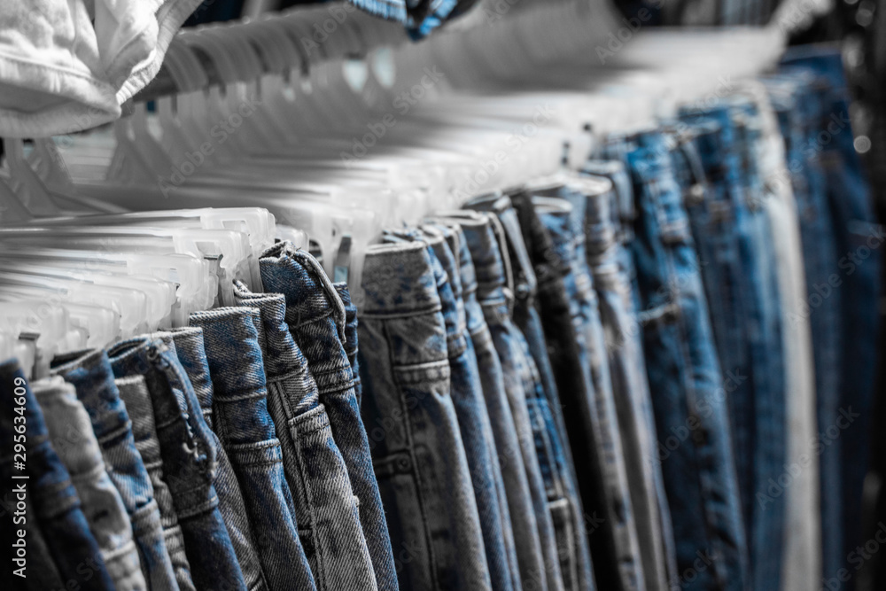 Fashion pants and jeans on the rack in clothing store. Sale
