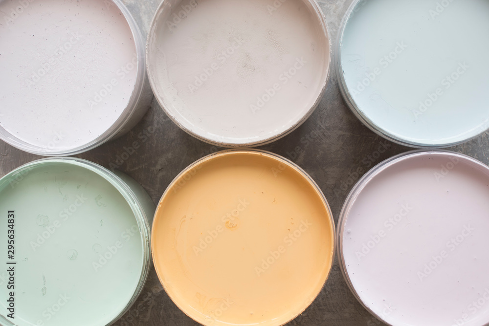 cans with open multi-colored paint on a gray background, top view cans with open multi-colored paint on a gray background, top view