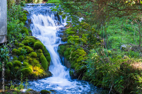 Small waterfall next to the old house in a yard in village Martin Brod in Bosnia and Herzegovina photo