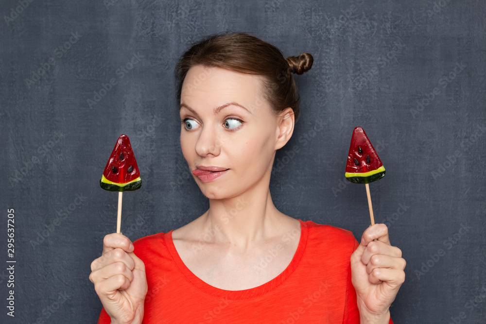 Portrait of pretty woman looking with appetite at tasty lollipop Portrait of pretty woman looking with appetite at tasty lollipop