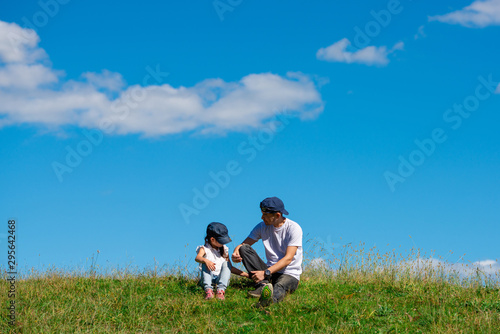 草原で座る父と娘