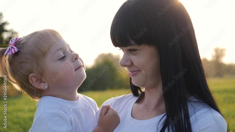 Happy family, mother and child have fun outdoors in the Park. The little lovely blonde girl is having fun and hugs and kisses her mother. Happy family, mother and child have fun outdoors in the Park. The little lovely blonde girl is having fun and hugs and kisses her mother.