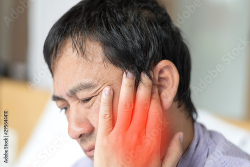TMD and TMJ healthcare concept: Temporomandibular Joint and Muscle Disorder. Asia man hand on cheek face as suffering from facial pain, mumps or toothache photo