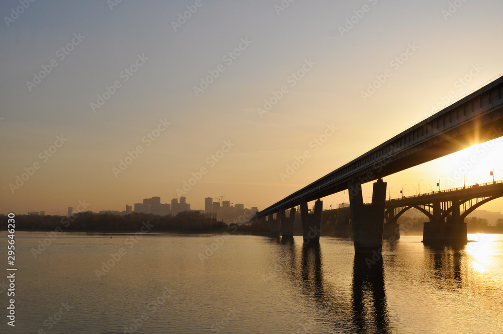 Bridge over the river against the backdrop of the city sunset