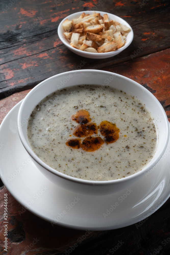 Traditional Turkish yogurt soup with croutons aside isolated on rustic wooden table Traditional Turkish yogurt soup with croutons aside isolated on rustic wooden table