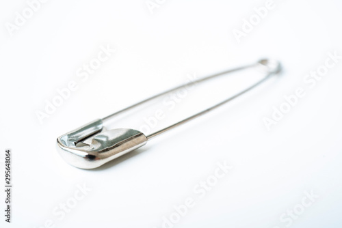 Macro metall safety pin for crafts  fashion  jewelry  hobby or household on white background with selective focus
