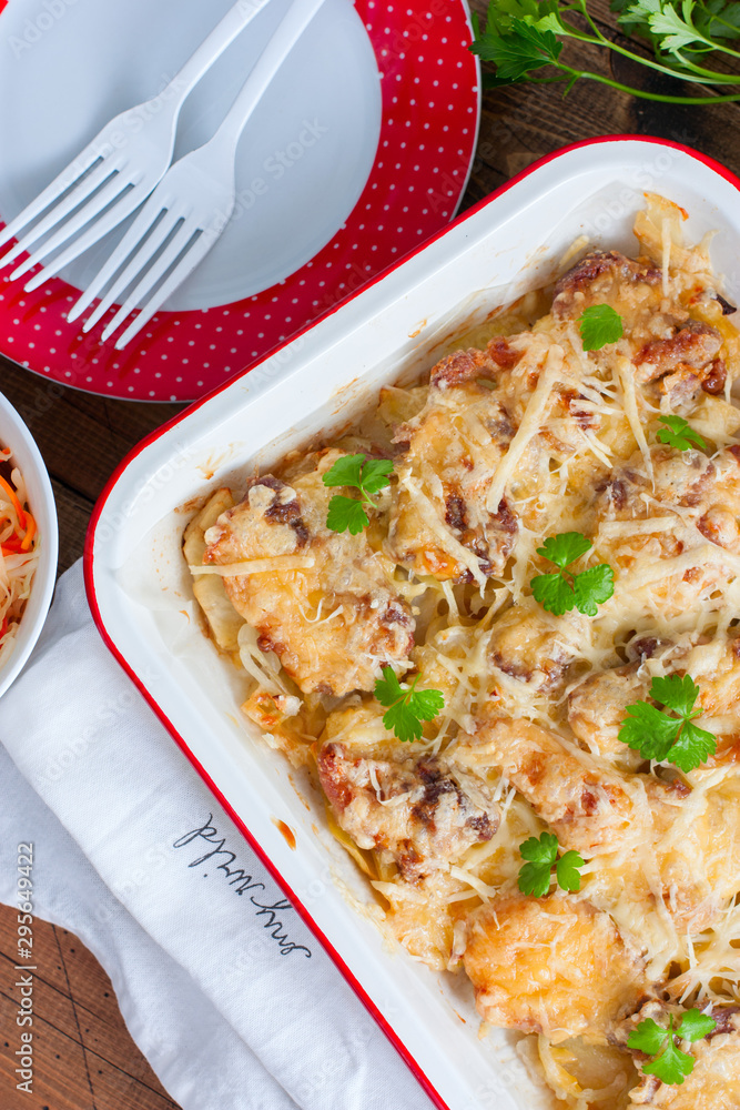 Baked sliced potatoes with pork and cheese, top view, selective focus Baked sliced potatoes with pork and cheese, top view, selective focus