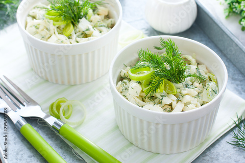 Spring salad with leek and eggs in portioned white bowls, horizontal