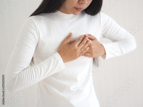 heart failure in woman and she press her chest symptom of pain and suffering cause of arrhythmia and bradycardia use for medicine product and health care concept on white background. photo