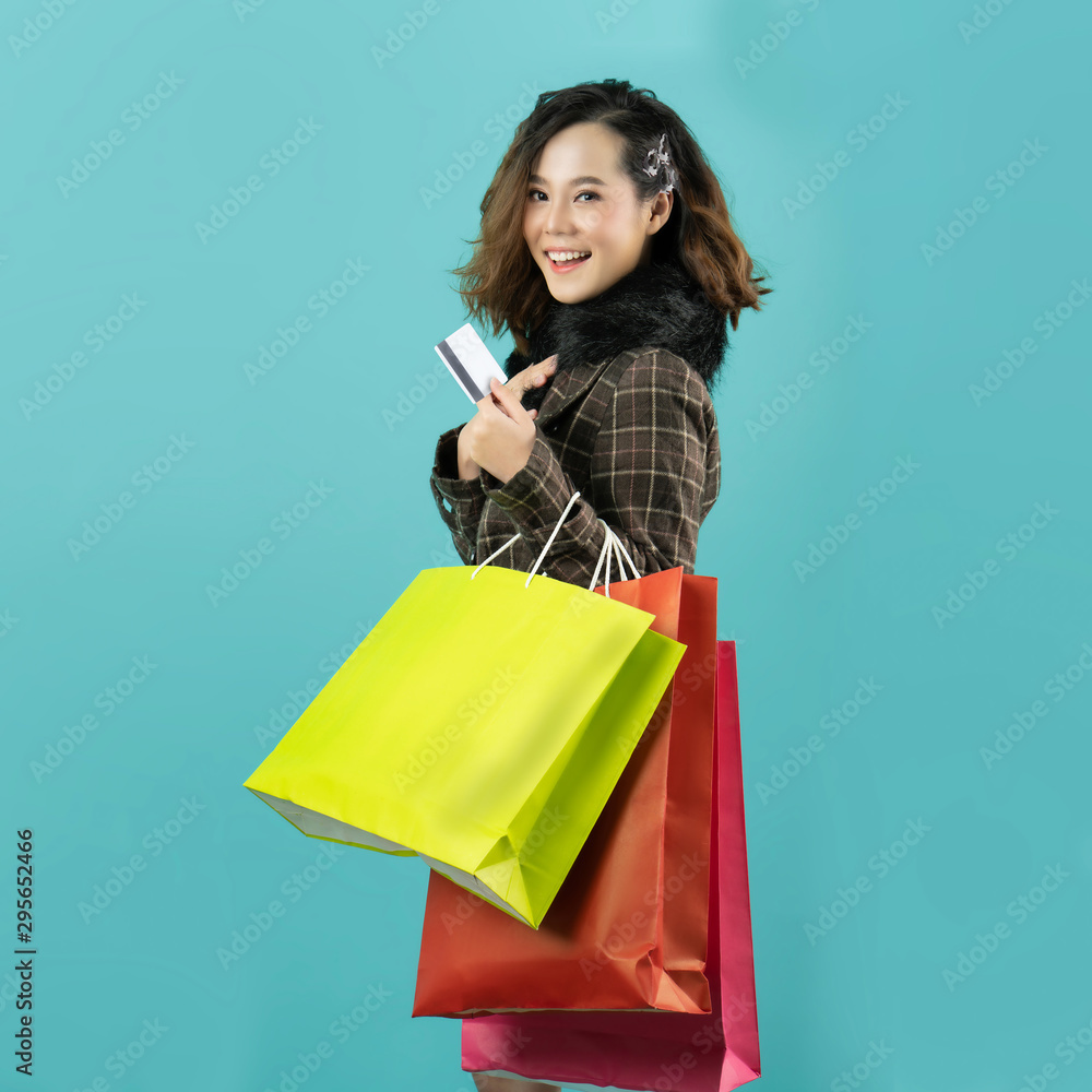 Asian woman are shopping in the winter she is using a credit card and enjoys shopping. Asian woman are shopping in the winter she is using a credit card and enjoys shopping.