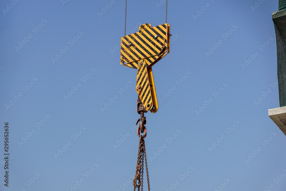 Closeup view of crane hook against blue sky Closeup view of crane hook against blue sky