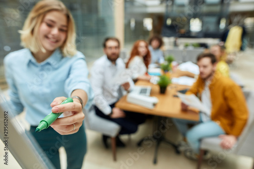 Foto Close up of green marker in delicate hand of young charming woman against blurre