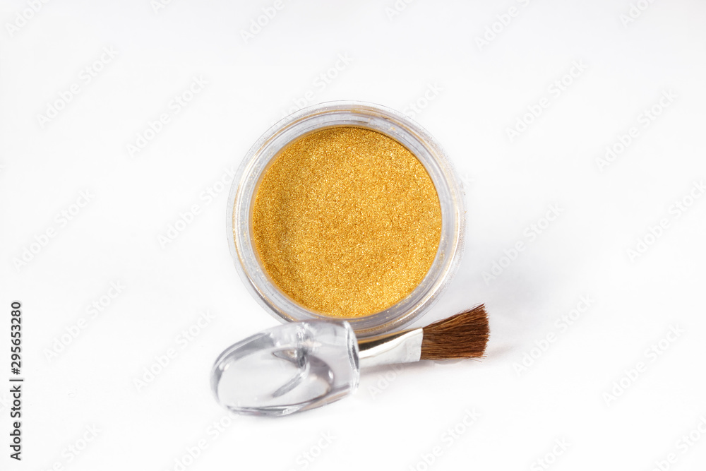 Gold eye shadows and eye brush isolated on white background. Concept of makeup and beauty. Gold eye shadows and eye brush isolated on white background. Concept of makeup and beauty.