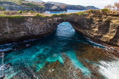 Broken Beach, on the island of Nusa Penida, Indonesia. Lagoon in foreground with rocks and clear turquoise water; rugged coastline in the distance. 