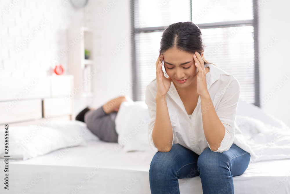 couple,they have problems with quarrel. woman sitting in bed She is having a headache couple,they have problems with quarrel. woman sitting in bed She is having a headache