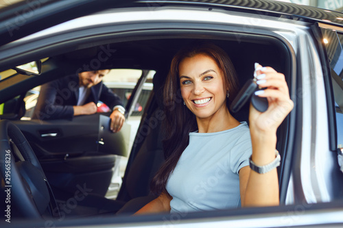 A male buyer is sitting in a new car.