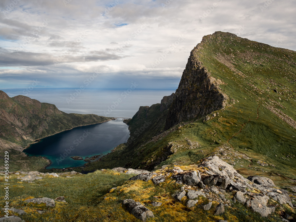 A mountain ride overlooking a small bay and a bridge in Lofoten, Norway.