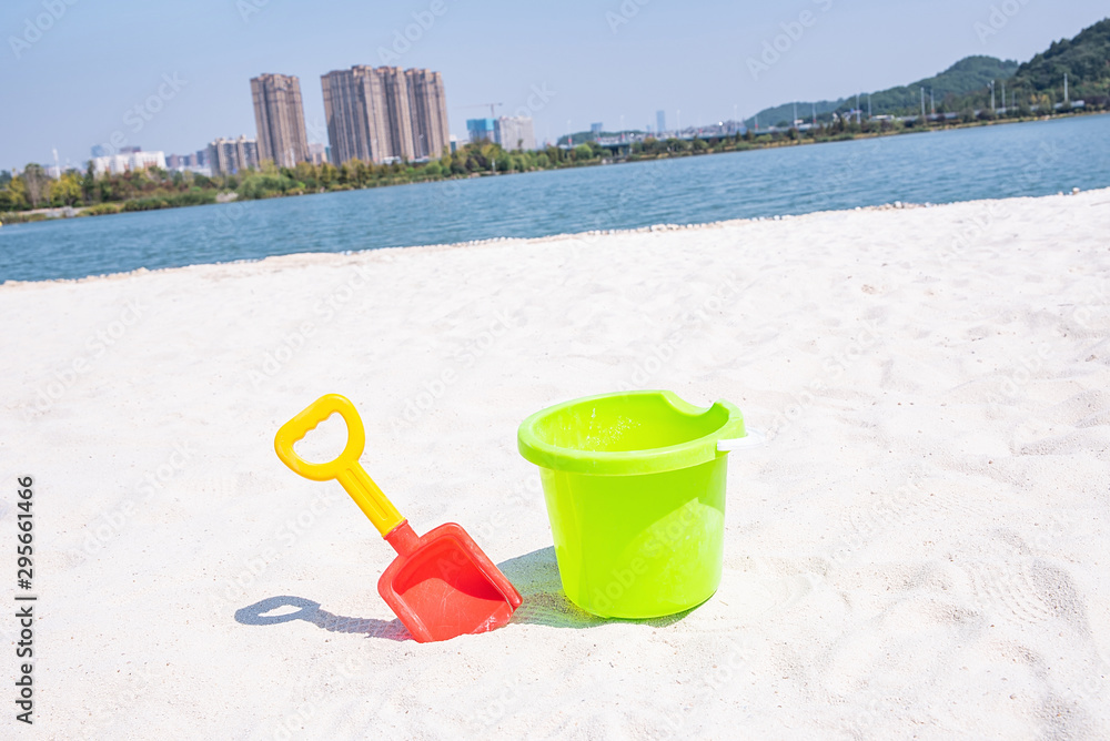 Children on white sand beach play with small tools and small shovel Children on white sand beach play with small tools and small shovel
