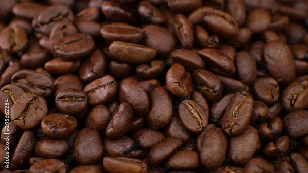 Coffee rotating on board Coffee beans clouse up. Beautiful seeds of coffee Coffee rotating on board Coffee beans clouse up. Beautiful seeds of coffee