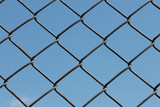 Wire mesh or netting fence against the sky