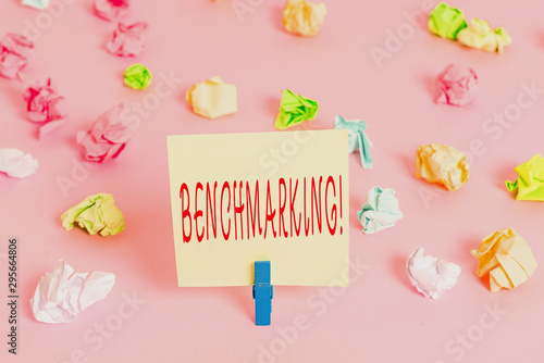 Writing note showing Benchmarking. Business concept for evaluate something by comparison with standard or scores Colored crumpled papers empty reminder pink floor background clothespin