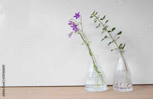 bouquet of flowers in glass vase on wooden background