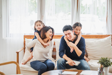 Happy Asian family playing together at sofa, home living room