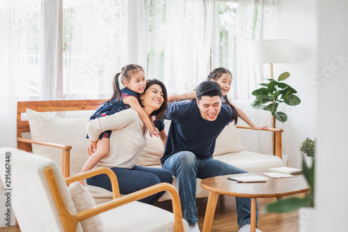 Happy Asian family playing together at sofa, home living room