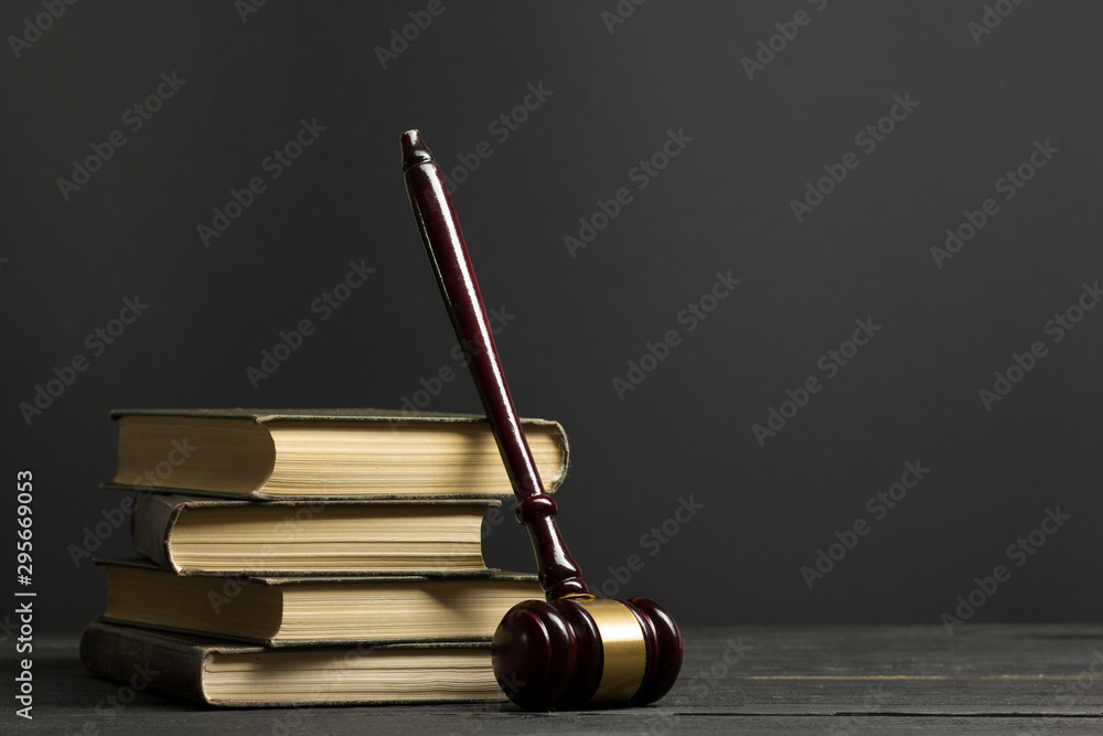 Law concept - Open law book with a wooden judges gavel on table in a courtroom or law enforcement office isolated on white background. Copy space for text.