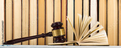 Legal Law concept - Open law book with a wooden judges gavel on table in a courtroom or law enforcement office. Copy space for text