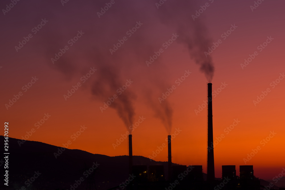 Smoke coming out from factory chimneys at sunset