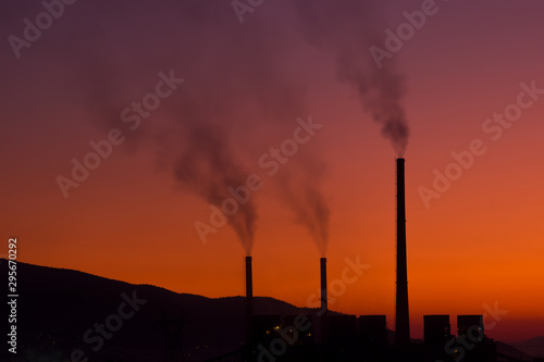Smoke coming out from factory chimneys at sunset