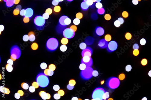 Many soft blue, white, orange and purple blurry bokeh light on dark background in Christmas and New Year festival day, can use for background