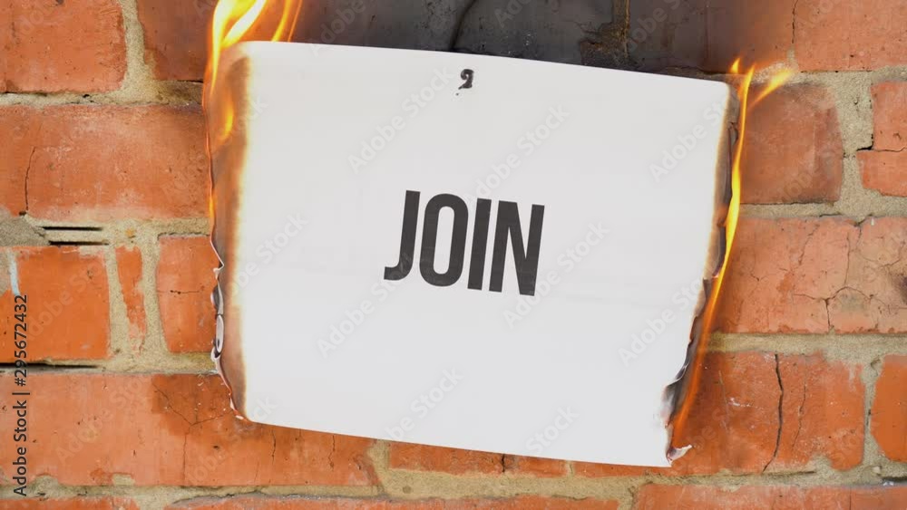 The inscription on a white A4 size sheet against the background of an orange brick wall. The paper with the black Join burns, smoke and turns into ashes. Business concept. The inscription on a white A4 size sheet against the background of an orange brick wall. The paper with the black Join burns, smoke and turns into ashes. Business concept.