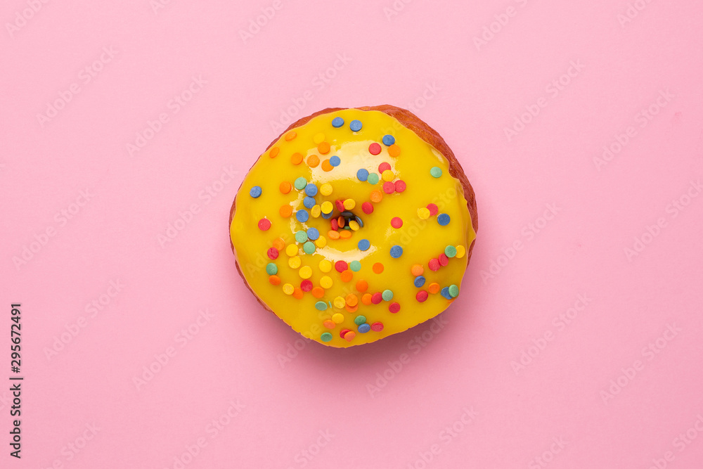 Sweet yellow donut with sprinkle on a pink background flat lay Sweet yellow donut with sprinkle on a pink background flat lay