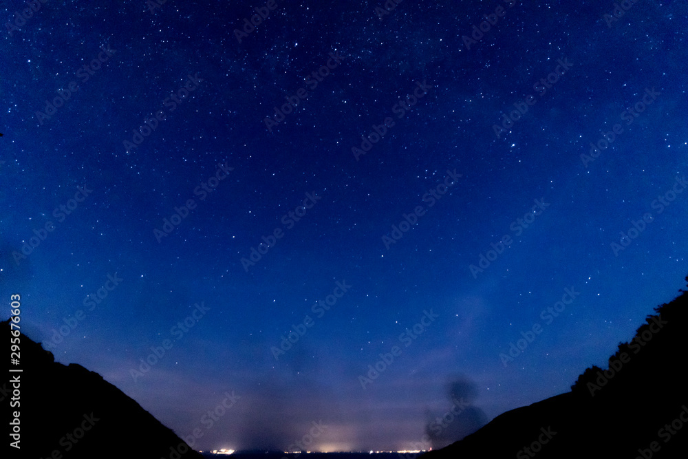Bright starry night with distant town glow