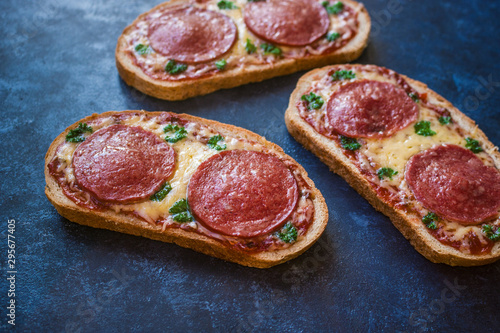 hot open sandwiches with salami cheese tomato sauce pepperoni pizza style   close up