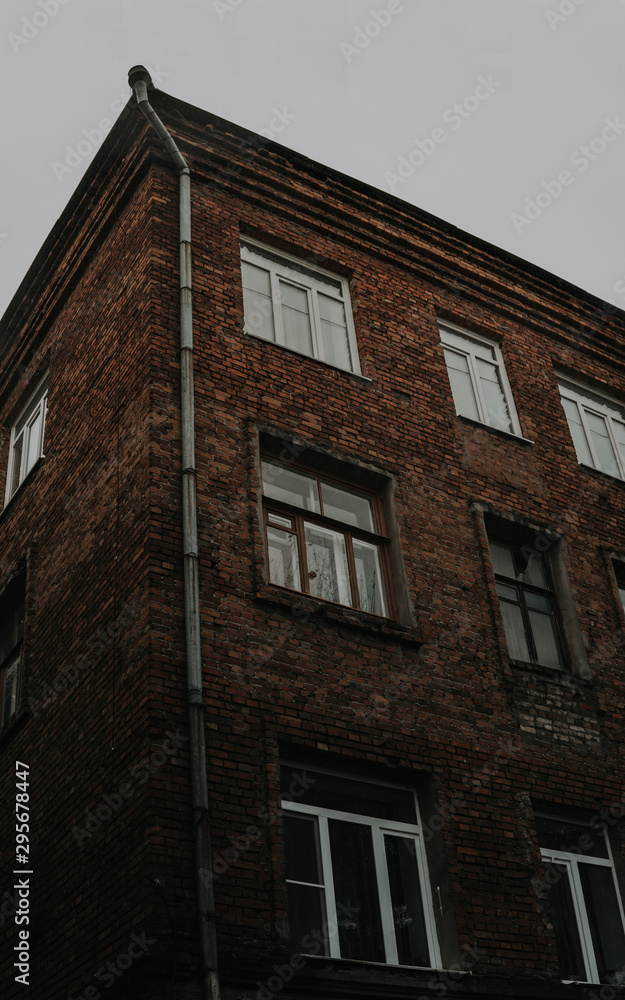 An old residential building against the gray sky. Architecture of Soviet Union times.