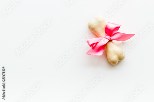 Small present for dogs. Chewing bones with bow on white background top view copy space