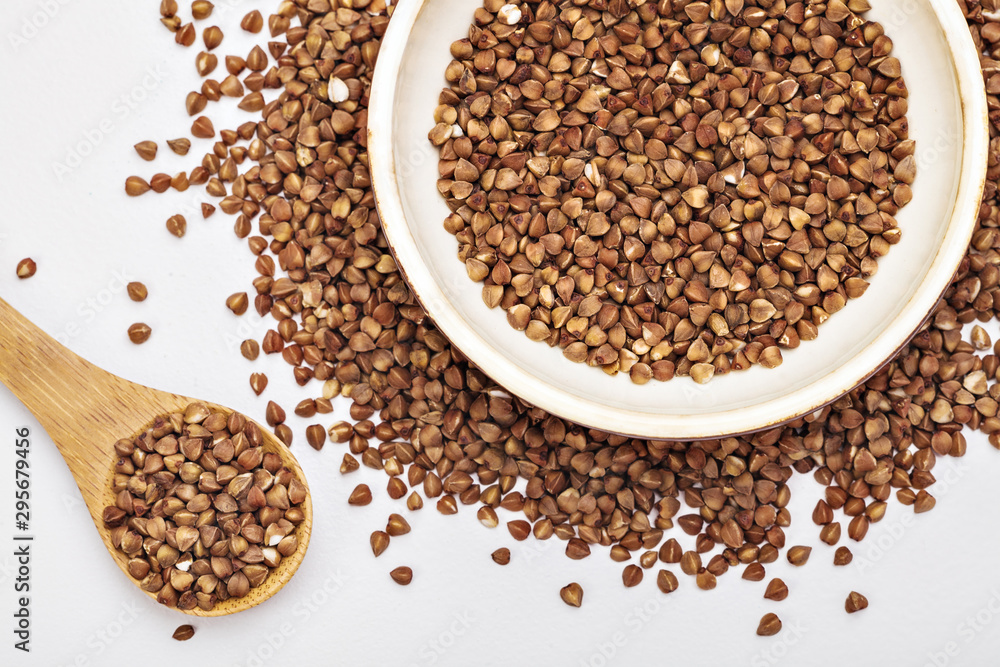 buckwheat in a plate and in a wooden spoon buckwheat in a plate and in a wooden spoon