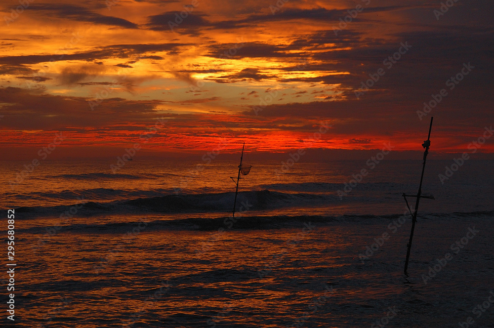 Fishing stilts in the sky full of colour in Dalawella, Sri Lanka Fishing stilts in the sky full of colour in Dalawella, Sri Lanka
