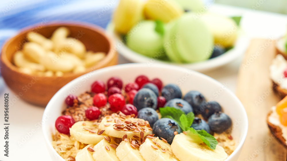breakfast top view white background. oatmeal with berries, toasts on a wooden tray, nuts, coffee breakfast top view white background. oatmeal with berries, toasts on a wooden tray, nuts, coffee
