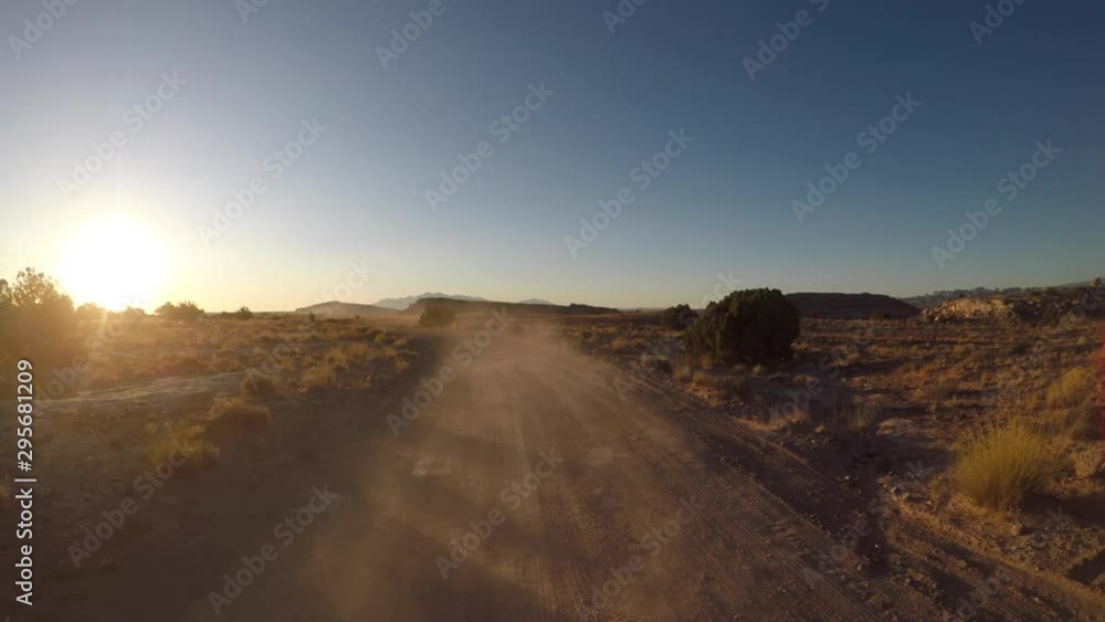Bright Sun Lights Dust On Dirt Road just after sunrise Bright Sun Lights Dust On Dirt Road just after sunrise