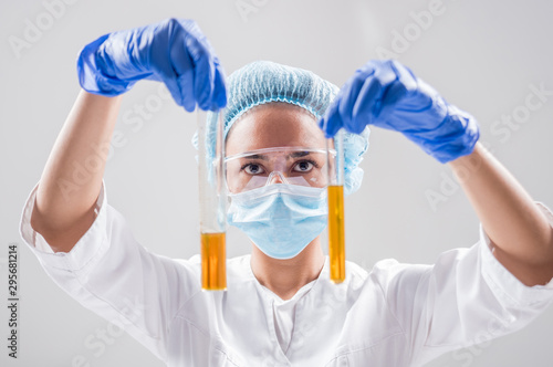 Scientist pouring organic oil. Beauty and cosmetics sciences. Laboratory equipment