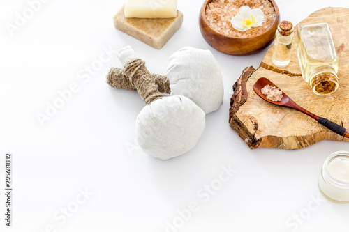 Massage thai herbal balls near spa accessories on white background space for text