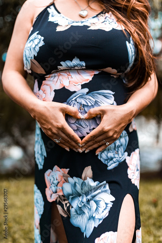 pregnant woman holding hands on her belly