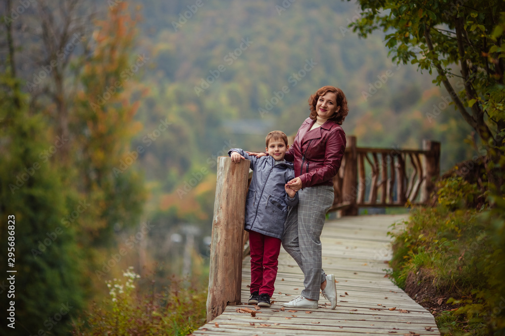 Travelers mother son in the autumn mountains for a walk.